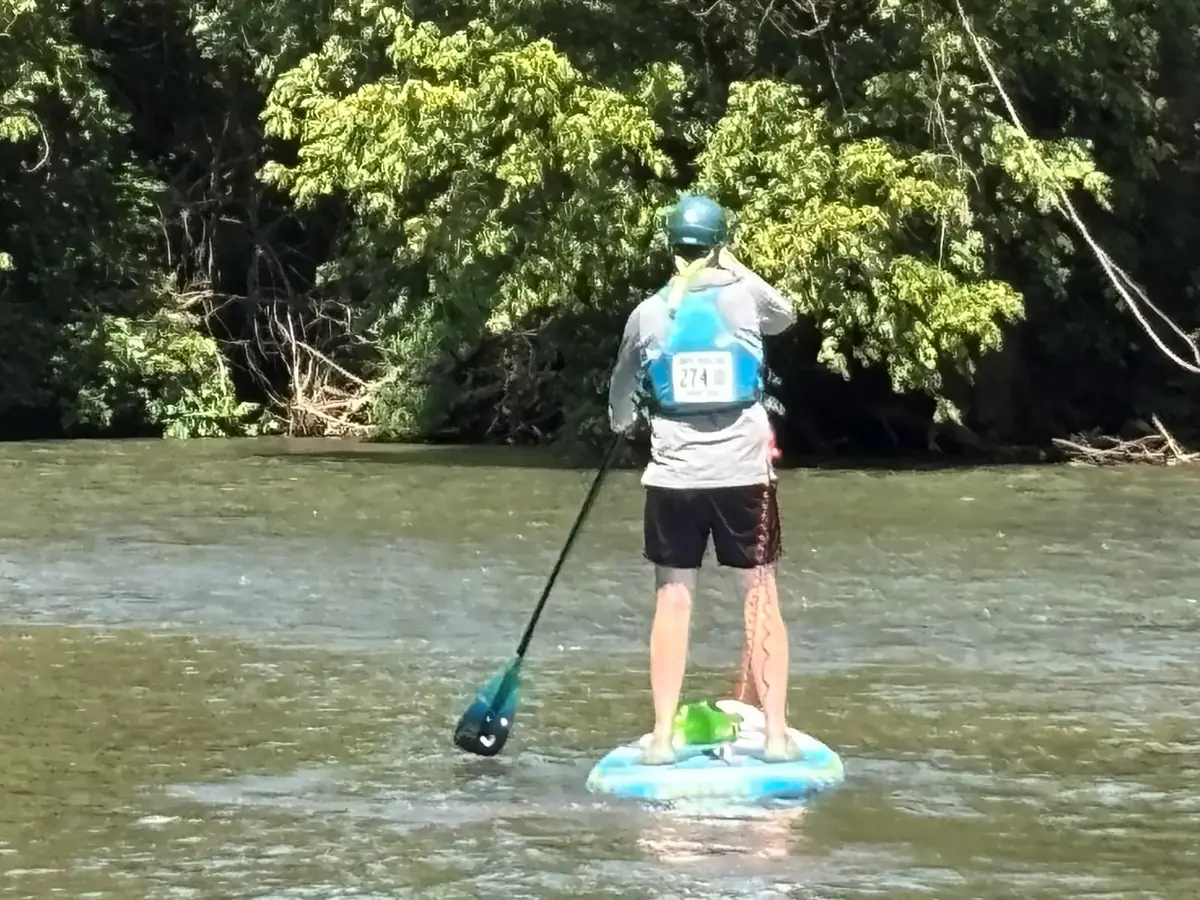 A guest paddleboarding on the Smith River
